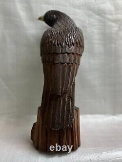 A Hand Carved And Contrastingly Stained Wood Eagle Perched On A Tree Stump