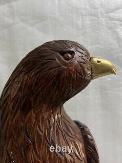 A Hand Carved And Contrastingly Stained Wood Eagle Perched On A Tree Stump